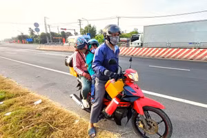 Người lao động miền Tây di chuyển trở lại nơi làm việc bằng xe gắn máy.