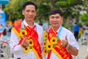 Thầy Trịnh Hoàng Thám (bên trái) chụp ảnh cùng đồng nghiệp khi nhận giải thưởng Cánh én hồng 2025.