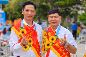 Thầy Trịnh Hoàng Thám (bên trái) chụp ảnh cùng đồng nghiệp khi nhận giải thưởng Cánh én hồng 2025.