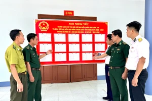 Cử tri cụm đảo Hòn Khoai, xã Đất Mũi xem danh sách niêm yết cử tri bầu cử.