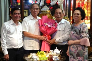Nguyên Chủ tịch Ủy ban Trung ương MTTQVN Nguyễn Thiện Nhân tặng hoa chúc mừng NGND Thái Văn Long.