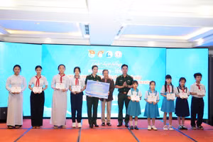 Bà Lê Minh Ngọc, Phó Chủ nhiệm CLB “Vì Hoàng Sa- Trường Sa thân yêu” trao học bổng cho đại diện Đồn Biên phòng và học sinh.