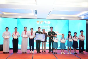 Bà Lê Minh Ngọc, Phó Chủ nhiệm CLB “Vì Hoàng Sa- Trường Sa thân yêu” trao học bổng cho đại diện Đồn Biên phòng và học sinh.