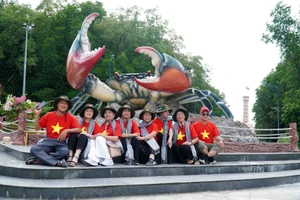 Du khách chụp ảnh tại Biểu tượng con cua trong Khu du lịch Mũi Cà Mau.