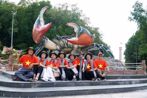 Du khách chụp ảnh tại Biểu tượng con cua trong Khu du lịch Mũi Cà Mau.