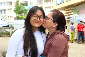 Phụ huynh ôm hôn khích lệ con thi tốt.
