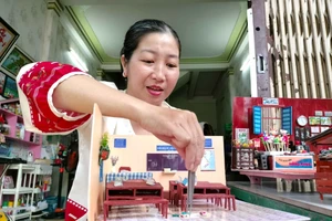 Chị Nguyễn Hồng Phúc đang làm mô hình trường học xưa.
