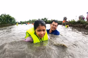 Cán bộ đoàn hỗ trợ dạy bơi cho trẻ em. Ảnh: Quách Mến.