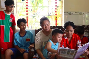 Bà Trương Thị Út quan sát các con học bài. Ảnh: Quách Mến