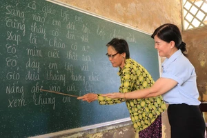 Bà Đào Thị Thanh An hướng dẫn một học trò cao tuổi đọc chữ.