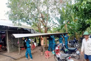 Lực lượng chức năng hỗ trợ người dân khắc phục nhà bị thiệt hại.