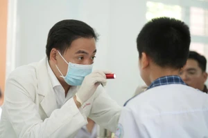 Bác sĩ khám và tư vấn sức khỏe răng miệng cho học sinh tại chương trình.