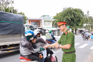 Cán bộ, chiến sĩ Công an phát nước suối và khăn lạnh cho người dân về quê nghỉ lễ.