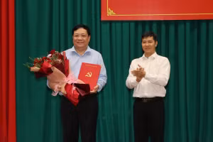 Ông Nguyễn Thành Tâm, Phó Trưởng Ban Tổ chức Trung ương trao Quyết định và hoa chúc mừng ông Phạm Thành Ngại. Ảnh: N.A.