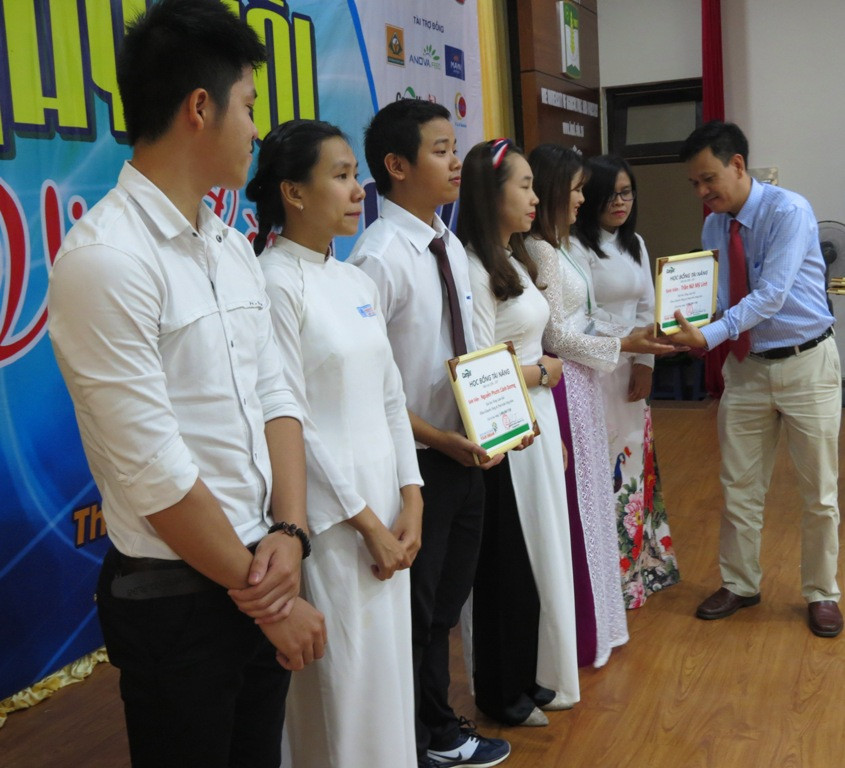 Đại diện các doanh nghiệp tặng học bổng cho các sinh viên nghèo vượt khó tại ngày họi việc làm của trường