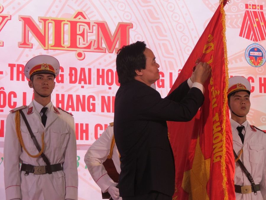 Bộ trưởng Bộ GD&ĐT Phùng Xuân Nhạ gắn Huân chương Độc lập lên lá cờ truyền thống của nhà trường