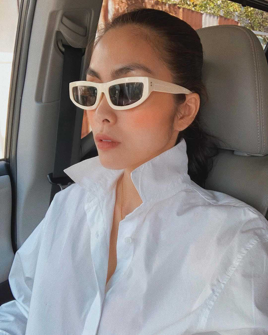 Là ngọc nữ ngoan hiền của màn ảnh nhưng Hà Tăng đôi khi cũng phá cách cho riêng mình với lối biến tấu quần áo. Trong ảnh, cô diện một chiếc áo sơ mi trắng rất bình thường, thậm chí nó còn được nhận xét là cứng dáng khi còn không có túi áo. Nhưng cô đã chứng minh rằng dù chỉ là món đồ tối giản, cũng có thể mặc đẹp và thời trang được khi bẻ chiếc cổ áo lên và đeo một chiếc mắt kính đen gọng trắng vào.