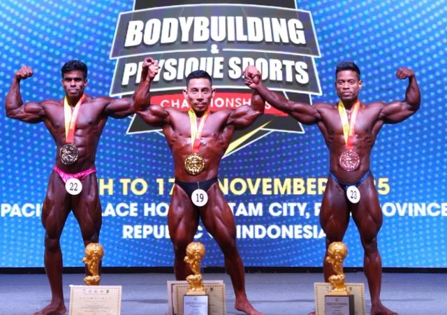 Vận động viên Phạm Văn Mách (giữa) vô địch Giải thể hình và fitness thế giới 2025 ở tuổi 49 (tức giải World Bodybuilding & Physique Sports Championships (WBPF)). 7766555.png