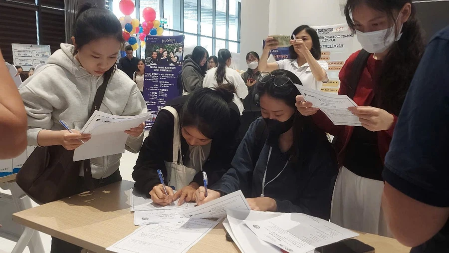 Các ứng viên điền thông tin tại các gian hàng tuyển dụng của doanh nghiệp tham gia Tuần lễ việc làm Đại học Duy Tân 2025. 