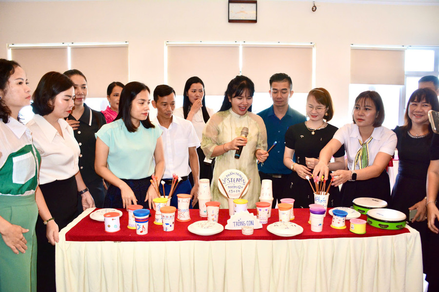 Giáo viên thuyết trình sản phẩm trống con làm từ ly giấy và bong bóng; maracas làm từ đĩa giấy và hạt đậu. viet-thuong-music.jpg