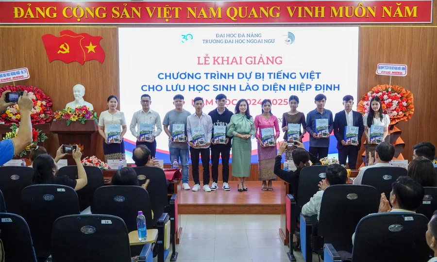 Đại diện Ban giám hiệu Trường Đại học Ngoại ngữ, Đại học Đà Nẵng tặng quà lưu niệm cho lưu học sinh Lào trong lễ khai giảng. 