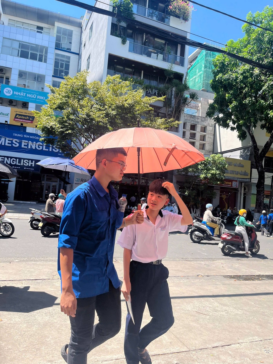 Tình nguyện viên Tiếp sức mùa thi tại Hội đồng coi thi Trường THPT Trần Phú vừa che nắng vừa động viên thí sinh dự thi. thpt-tran-phu.jpg