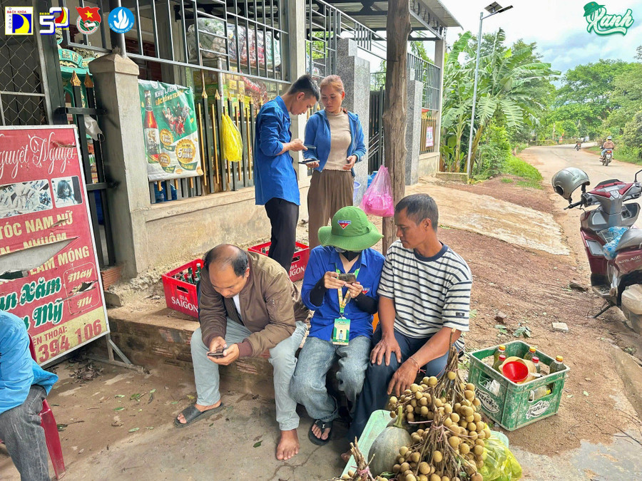 Sinh viên tình nguyện Trường Đại học Bách khoa - Đại học Đà Nẵng hỗ trợ người dân sử dụng dịch vụ công bằng thao tác trên điện thoại.