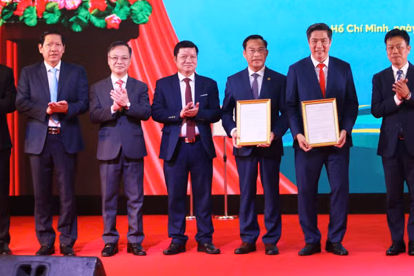 Thứ trưởng Bộ GD&ĐT Lê Quân (bìa phải) trao Quyết định thành lập và Quyết định cho phép hoạt động đào tạo của Phân hiệu Học viện Tài chính tại TPHCM.