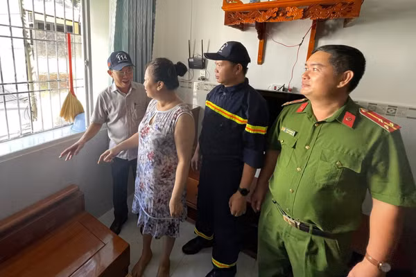 Ông Mai Quang, Phó Chủ tịch UBND phường Bình Quới (trái) cùng lực lượng chức năng vận động người dân chung cư Thanh Đa tháo dỡ "chuồng cọp". (Ảnh: Hà An)