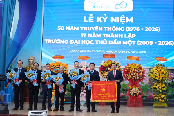 Lãnh đạo UBND TPHCM trao Cờ truyền thống tặng Trường Đại học Thủ Dầu Một. Ảnh: NTCC.