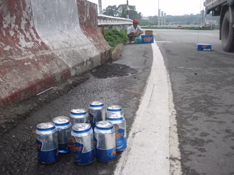 Người dân giúp tài xế thu gom lại gọn gàng số bia bị rơi xuống đường.