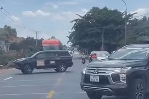 2 xe ô tô án ngữ tuyến quốc lộ, buộc các phương tiện khác phải dừng lại nhường đường.