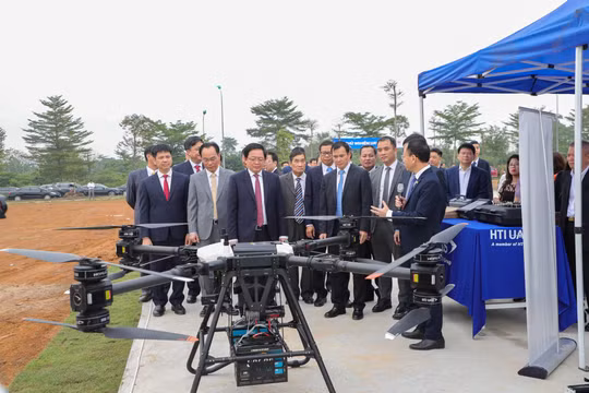 Phó Thủ tướng Hồ Quốc Dũng, Bộ trưởng Bộ GD&ĐT Hoàng Minh Sơn cùng các quan khách thăm quan khu thử nghiệm UAV của Đại học Quốc gia Hà Nội. Ảnh: VNU.