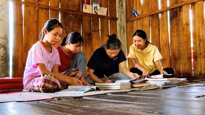 Các con, cháu của vợ chồng anh Pấng, chị Hồng soạn lại sách cũ để sử dụng cho năm học mới. 