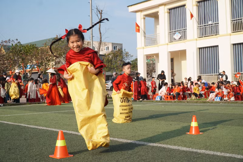 Niềm vui của học trò ngôi trường vùng biển Cửa Lò, Nghệ An khi tham gia tết ở trường, chơi trò chơi nhảy bao bố. Ảnh: Hồ Lài tet-cho-hoc-tro-vung-kho-6.jpg