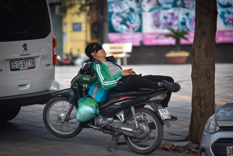 Những vỉa hè dưới tán cây là địa điểm để người tài xế xe ôm công nghệ này chợp mắt nghỉ trưa. c5.jpg
