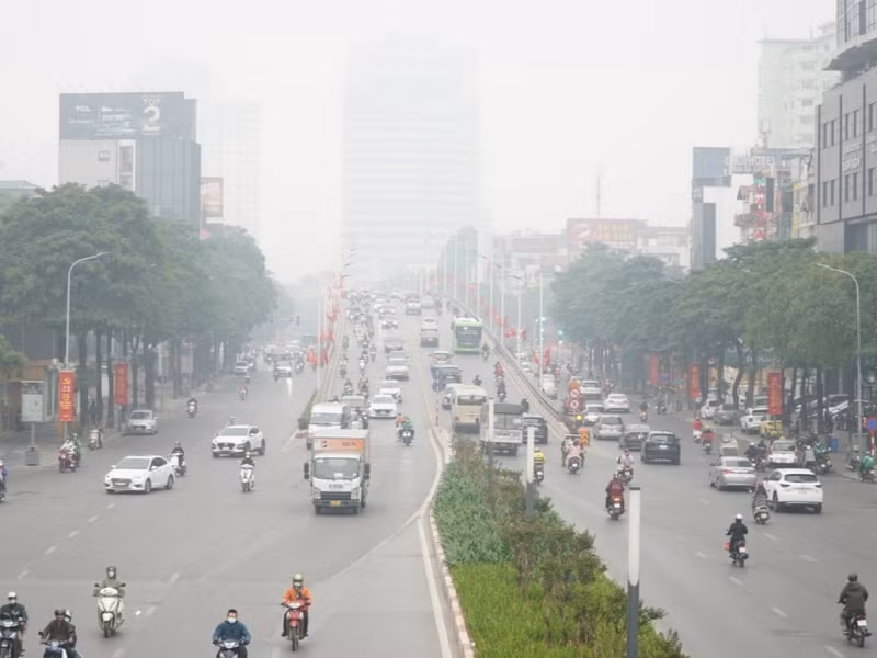 Nhiệt độ hạ thấp kết hợp với cơn mưa phùn, người dân khi ra ngoài đều phải mặc áo ấm và áo mưa. m2.jpg