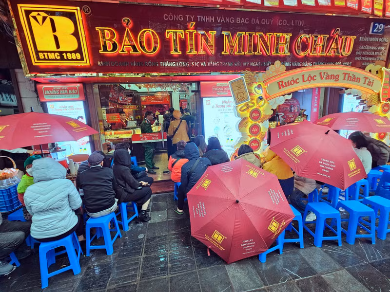 Sáng 6/2 (tức mùng 9 Tết Ất Tỵ), trên phố Trần Nhân Tông (Hà Nội) nhiều người dân đội mưa rét xếp hàng để mua vàng ngày Vía Thần Tài. v1.jpg