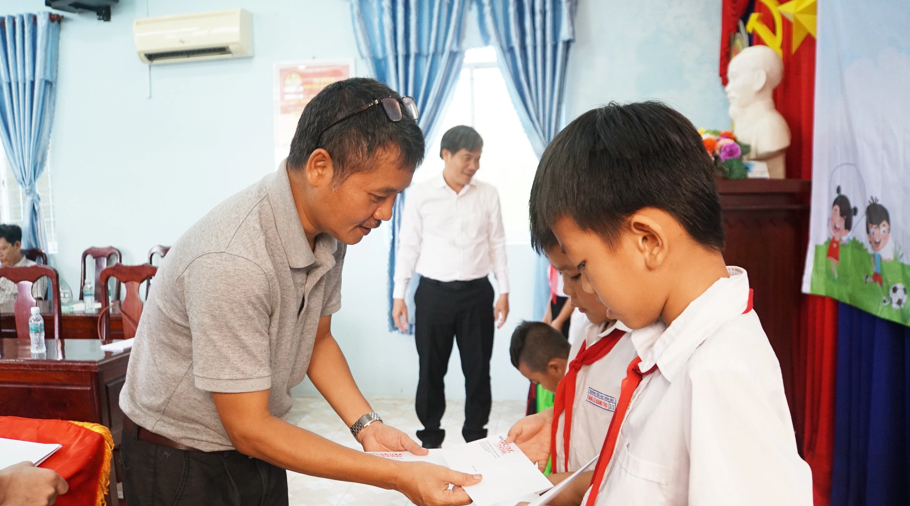 Nhà báo Nguyễn Đức Tuân, Phó Tổng biên tập Báo Giáo dục và Thời đại trao học bổng cho học sinh. Ảnh: Mạnh Tùng