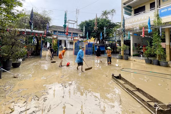 Các thầy cô giáo dọn bùn đất sau lũ tại sân trường Tiểu học Phú Bình, phường Phú Xuân chiều 30/10.