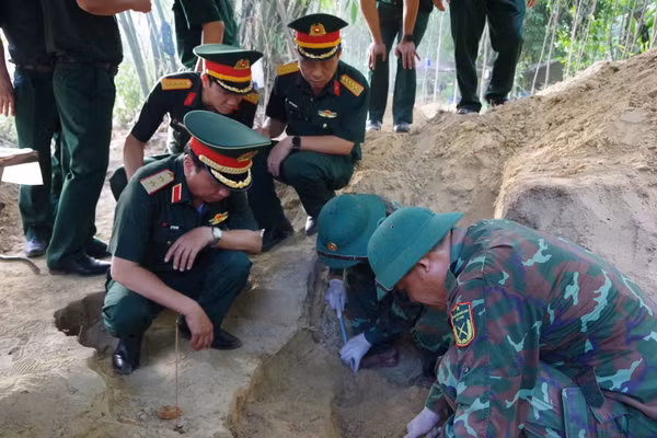 Lực lượng chức năng quy tập hài cốt liệt sĩ hy sinh ở Câu Nhi. Ảnh: Xuân Diện