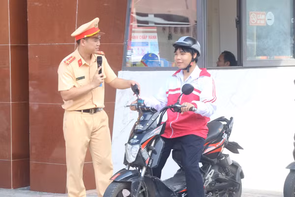 Cán bộ CSGT hướng dẫn học sinh các kỹ năng tham gia giao thông an toàn.