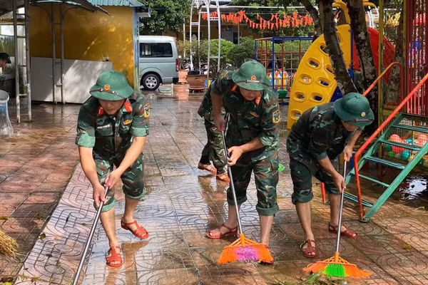 Bộ đội tham gia quét dọn vệ sinh khuôn viên trường học.