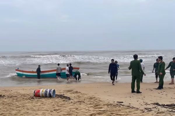 Các lực lượng chức năng kéo tàu cá vào bờ.