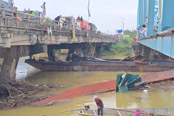 Lực lượng chức năng di dời chiếc sà lan ra khỏi cầu Mỹ Chánh.