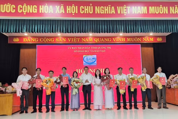 Bà Lê Thị Hương, Giám đốc Sở GD&ĐT và ông Võ Văn Minh, Phó Giám đốc Sở GD&ĐT trao quyết định và chúc mừng 10 Hiệu trưởng sau sắp xếp.