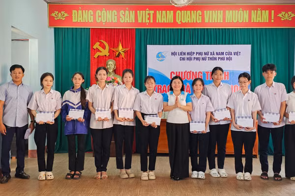 Đại diện Hội LHPN xã và đơn vị tài trợ trao quà đến học sinh.