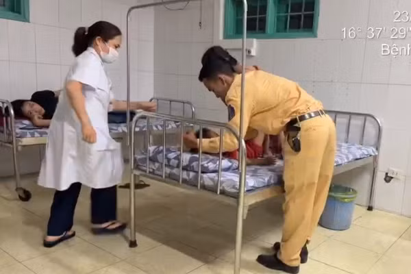 Cán bộ CSGT hỗ trợ đưa cháu bé vào phòng cấp cứu. 