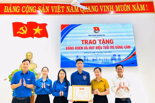 Bà Trần Thị Thu, Bí thư Tỉnh Đoàn Quảng Trị trao Bằng khen và Huy hiệu “Tuổi trẻ dũng cảm” cho em Lê Đức Trung.