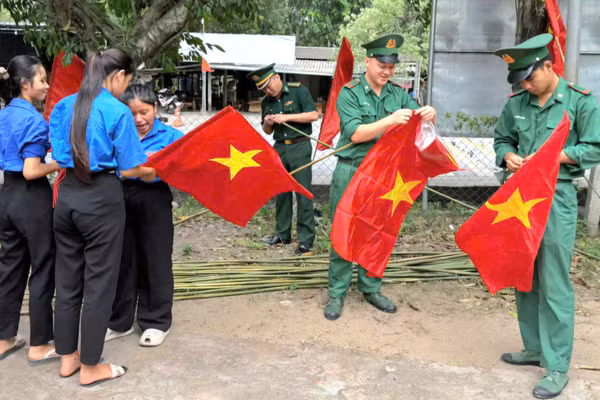 Bộ đội Biên phòng Quảng Trị cùng đoàn viên thanh niên treo cờ ở các tuyến đường.